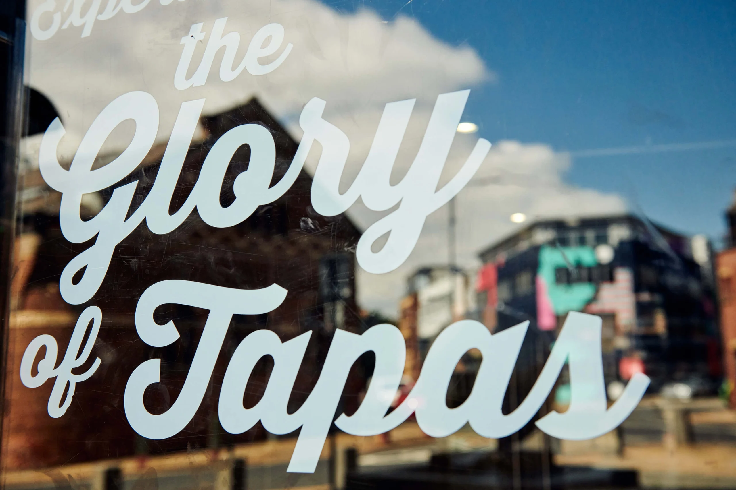 A local restaurant window with "the glory of tapas" in graphic print