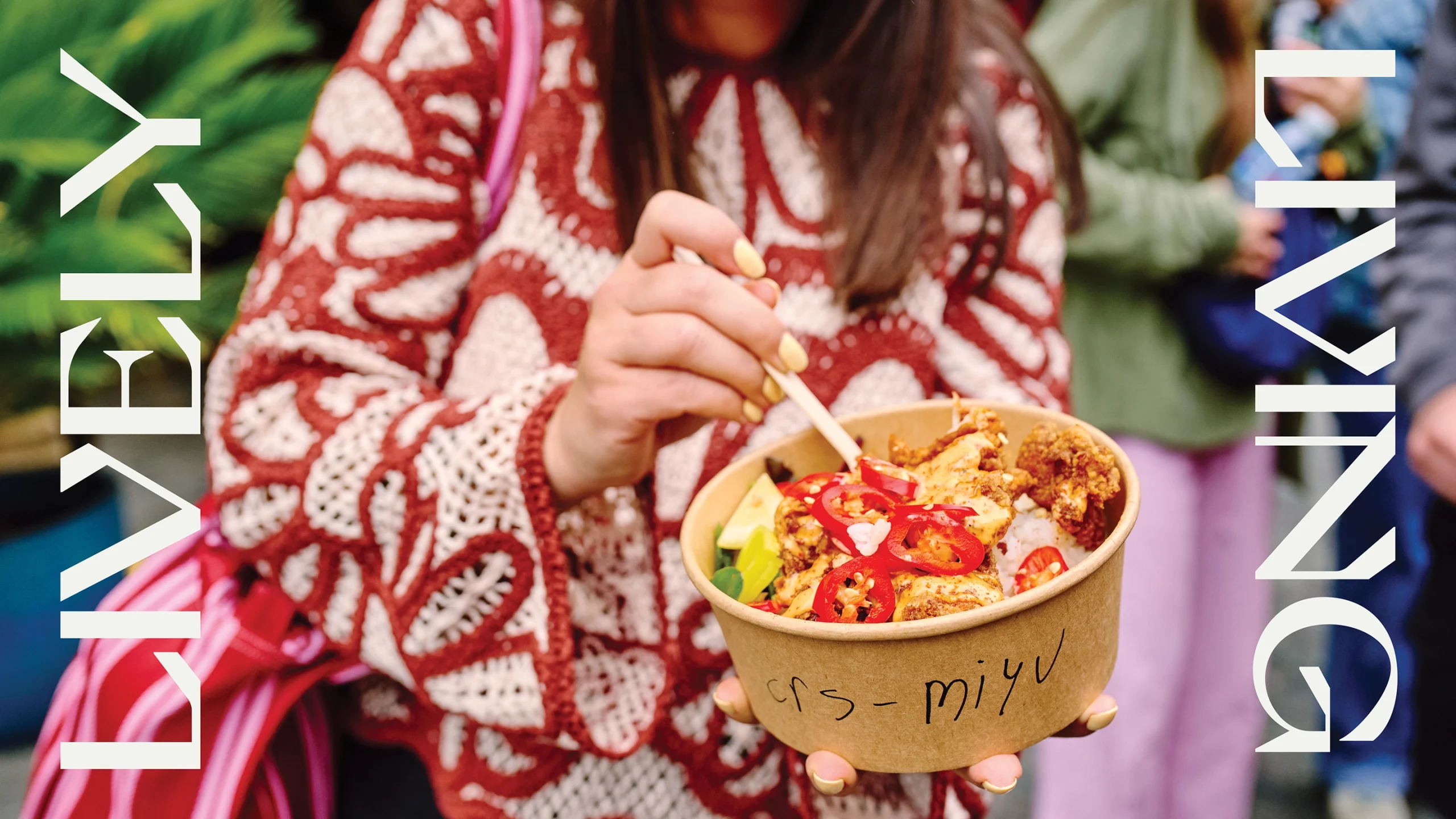 A woman holing a bowl of fried chicken from an outdoor market, with the words "lively" and "living" either side of her in graphic text