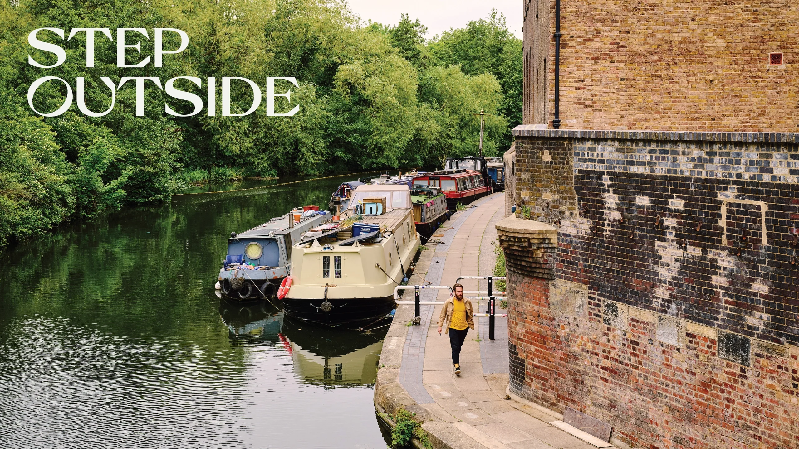 An image of boats on a canal next to a man walking alongside a wall, with the words "Step Outside" in graphic text